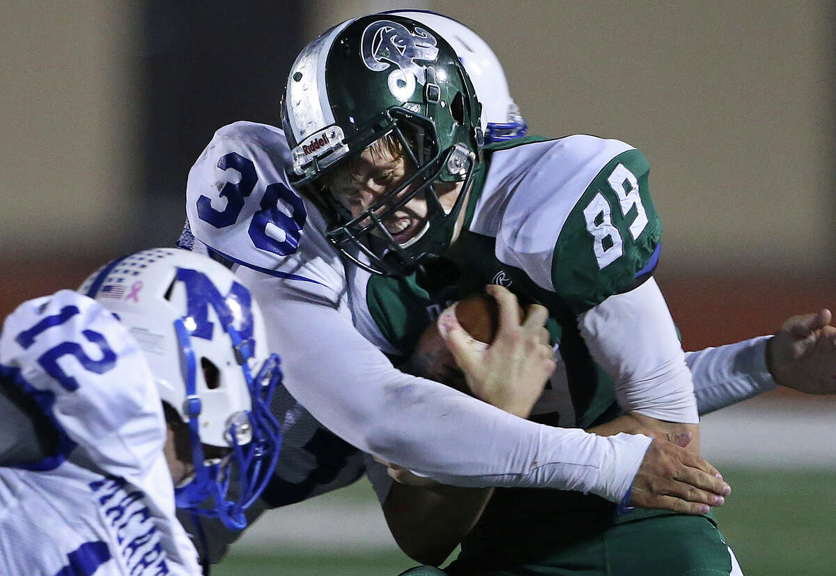 Rattler receiver Luke Mitchum takes a hit from Joey Fiel (38) after a catch as MacArthur plays Reagan at Comalander Stadium on October 24, 2014.