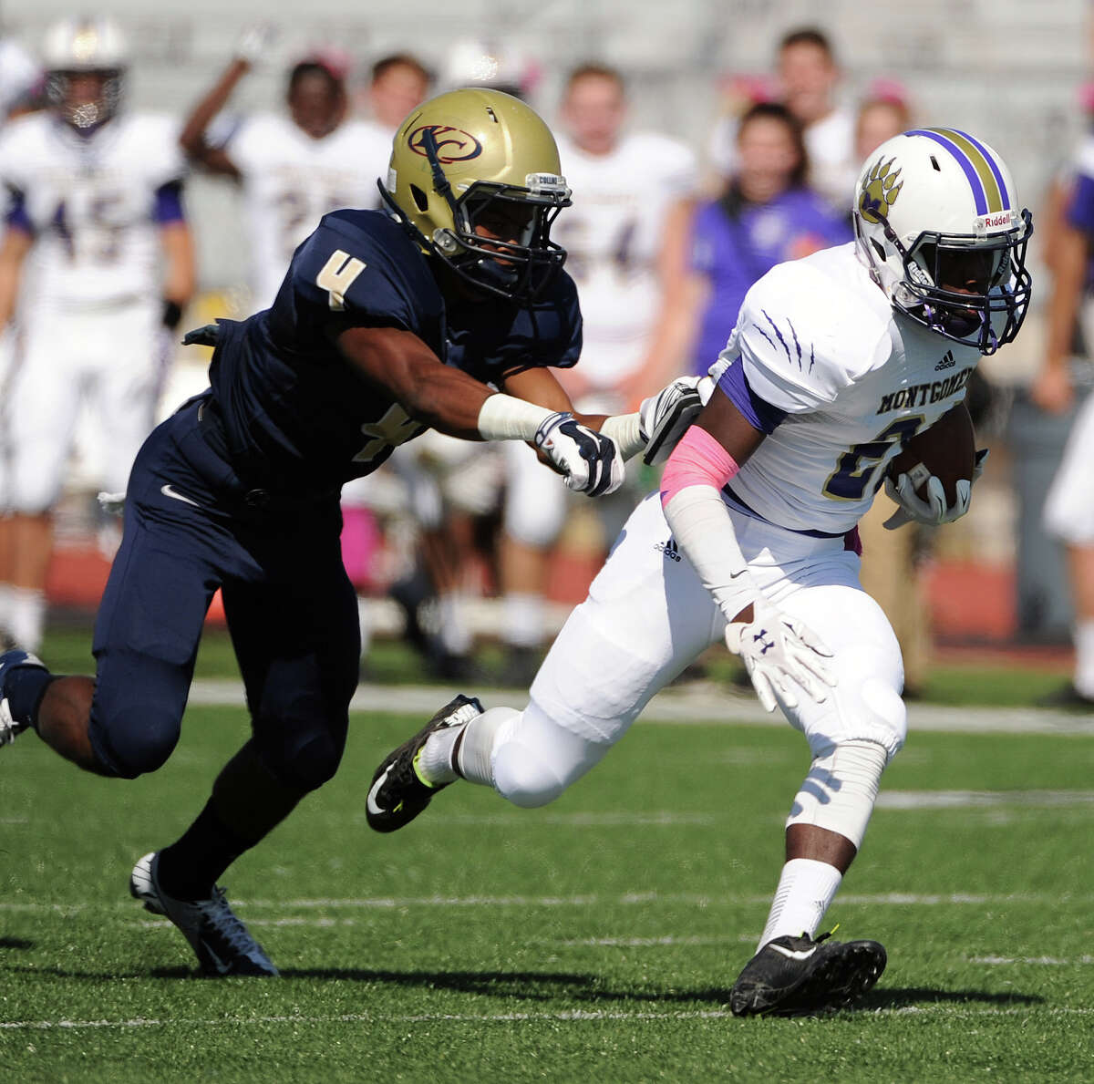 Montgomery wide receiver Anthony Thomas, right, escapes the tackle of Klein Collins defensive back Joseph Graves en route to a 63-yard touchdown during the first half of a high school football game, Saturday, October 25, 2014, at Klein Memorial Stadium in Houston.