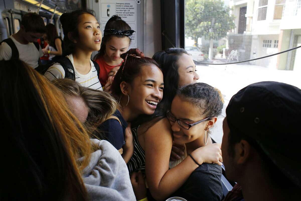 Ysabelle Capitule, 15, Maya Luna Imperial, 15, and Nasha Harris Santiago, 15, all students from the San Francisco School of the Arts crowd together on the J Church line to see performances at the annual Trolly Dances and Kids on Track performances in San Francisco, Calif.