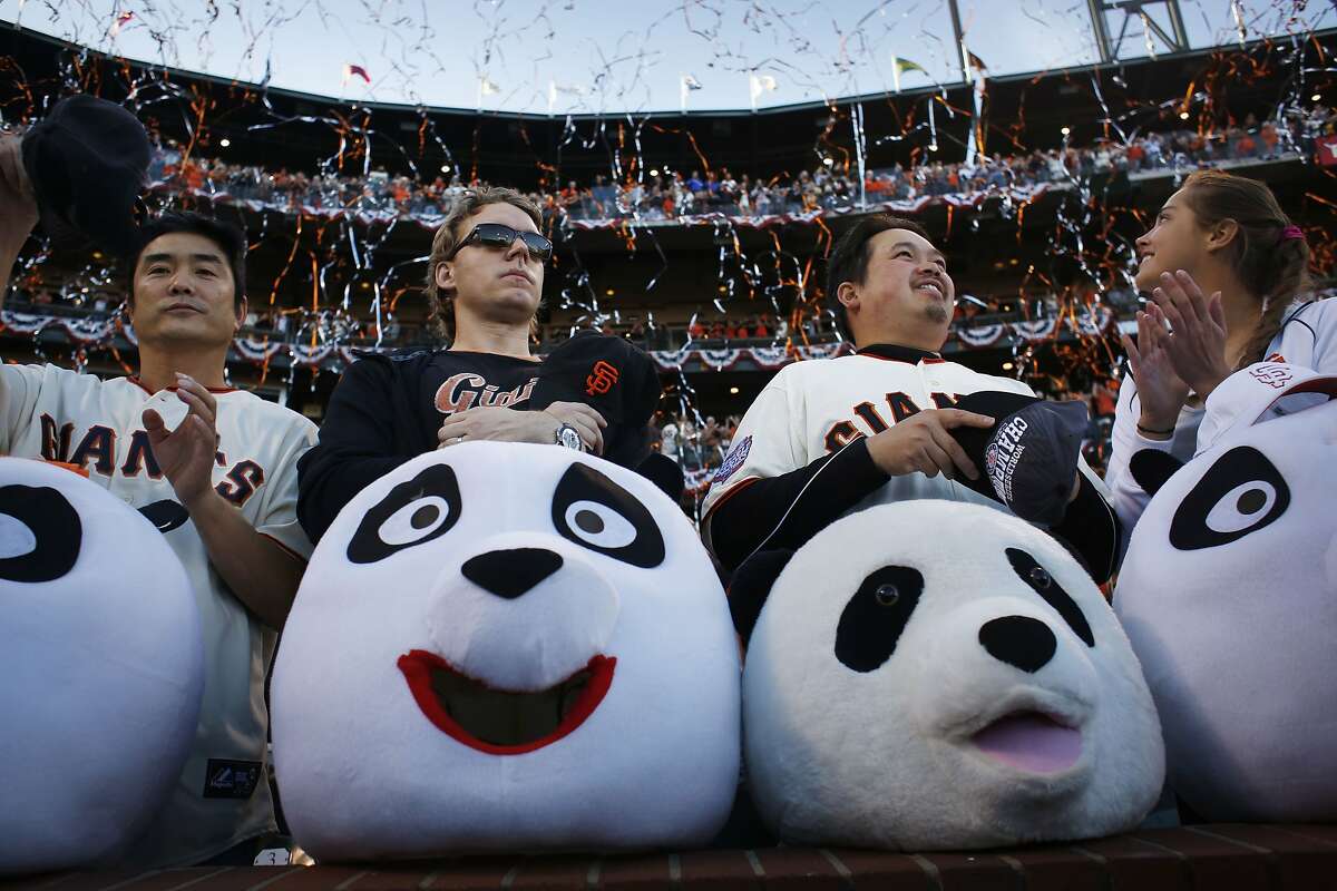 Giants fans known for wearing larger-than-life panda heads Jimmy Wong, Michael Jessen, Sam Wong and Bianca Ruiz put their heads down during the national anthem at the start of game five of the World Series against the Kansas City Royals at AT&T Park on Sunday Oct. 26, 2014 in San Francisco, Calf.
