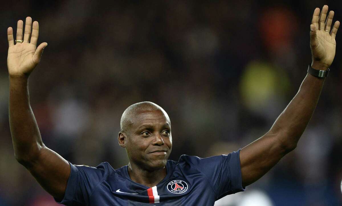 US sprint and long jump legend Carl Lewis acknowledges football fans before the start of the French L1 football match between Paris Saint-Germain (PSG) and Monaco at the Parc des Princes stadium in Paris on October 5, 2014. AFP PHOTO / FRANCK FIFEFRANCK FIFE/AFP/Getty Images