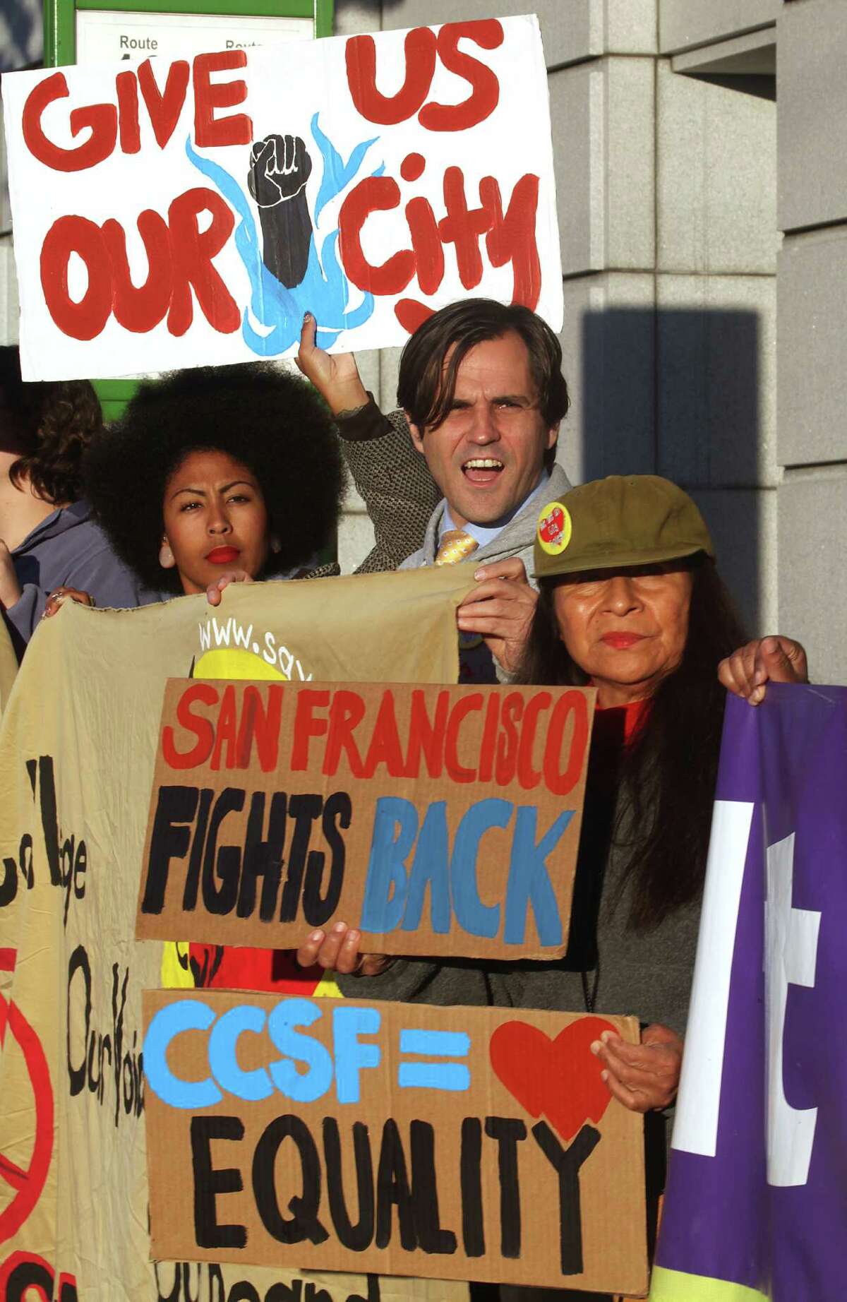 Educators and students including president of the Black Student Union Thea Matthews (left), student Keith Kimber (middle), and teacher Ana Chavez Fisher (right) of child development in family studies rally in support of CCSF and public education in front of the California State Superior Courthouse in San Francisco, Calif., on Monday, October 27, 2014.