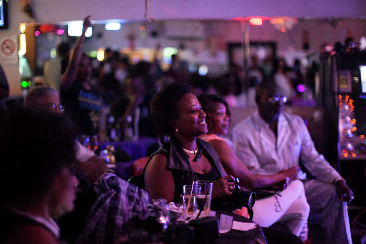 (Center) Tina Calhoun watches singers perform Wednesday October 22, 2014 during karaoke night at Nairobi Bar & Grill.