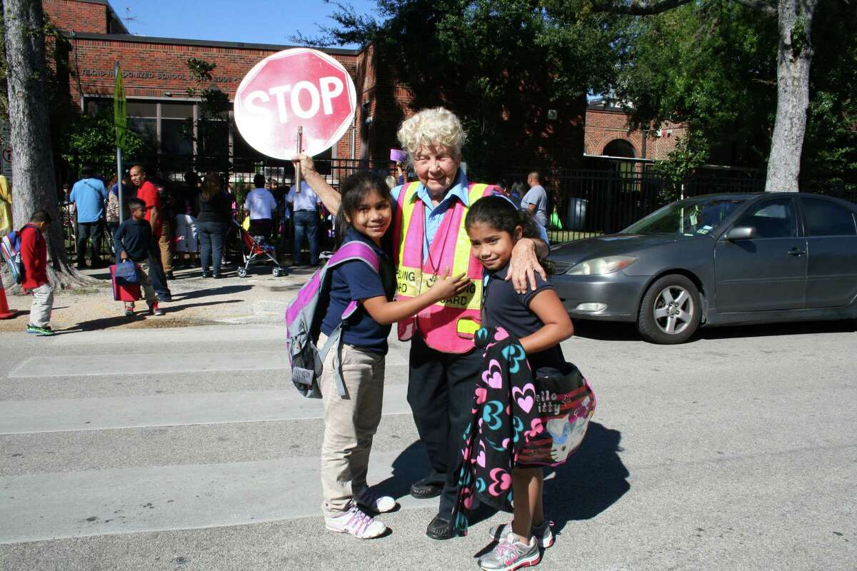 Helms Elementary School crossing guard Joy Wilson gets hugs from Cristel and Tereza Tomas.
