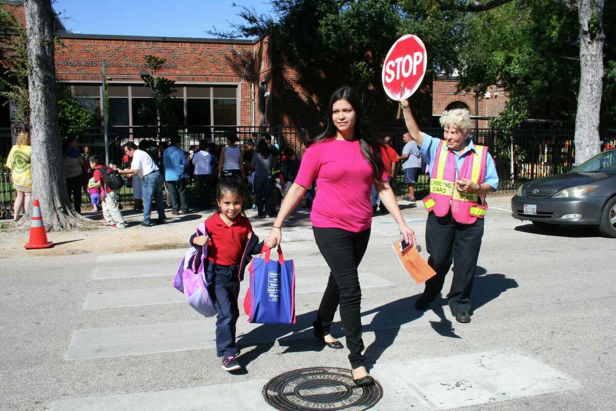 Joy Wilson, right, has been helping people like Isabella Villalpando and her mom Elisabeth Rangel cross the street in front of Helms Elementary School for 40 years. She said she plans to continue in the job "as long as I am physically able."