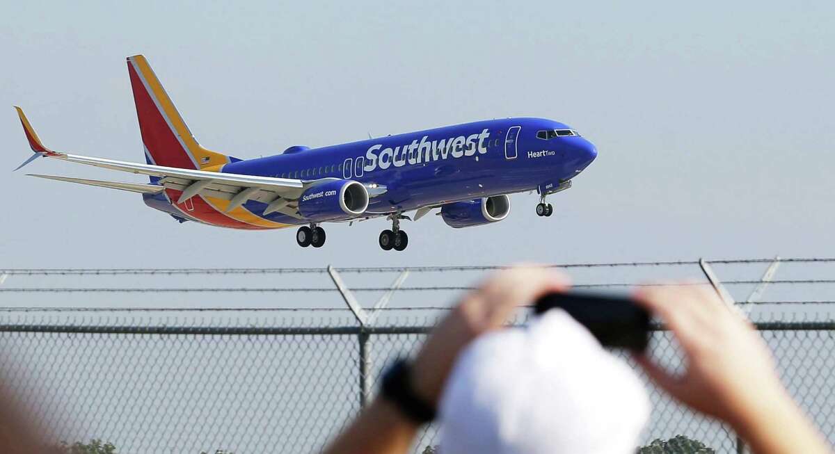 A Southwest Airlines plane with a new paint job flies over Love Field in Dallas. Southwest will begin nonstop service from San Antonio to Mexico City on Sunday, taking over the route previously operated by AirTran Airways.
