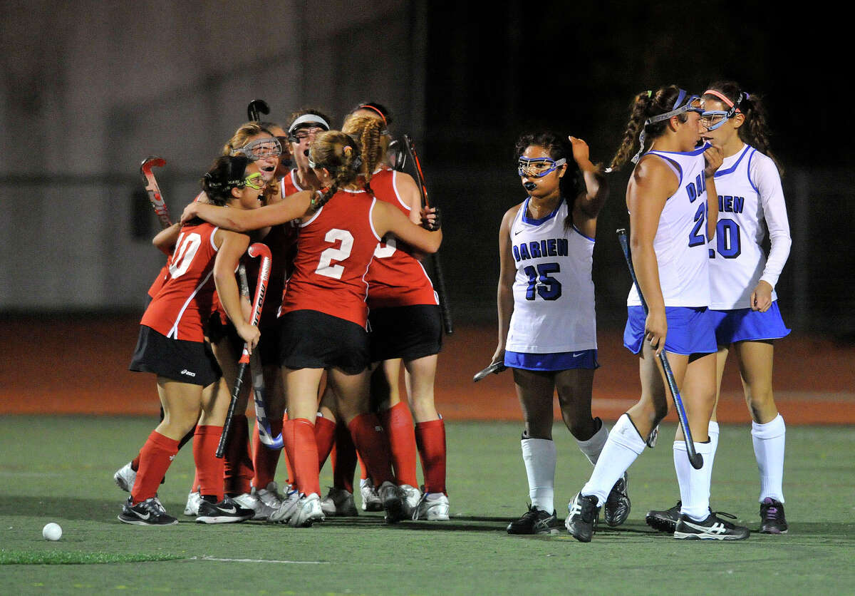 The New Canaan team celebrates after their team mate Isabel Taben scored her second goal on Darien during their FCIAC field hockey championship game at Brien McMahon High School in Norwalk, Conn., on Thursday, Oct. 30, 2014. New Canaan took home the title beating Darien, 2-0.