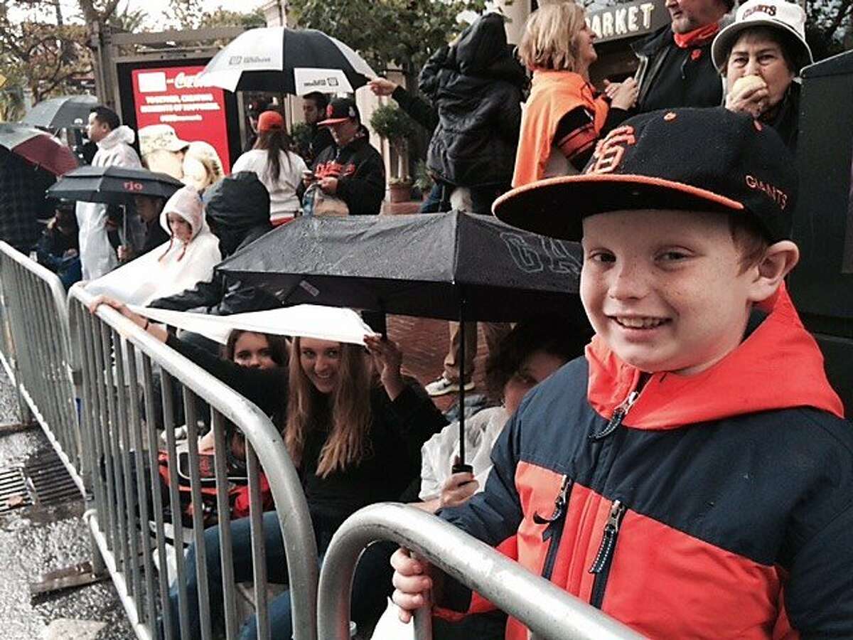Jakob Hilton,7 (right) waits for the SF Giants World Series parade on Fri. Oct. 31, 2014. He's not playing hooky. Sonoma schools were out today.