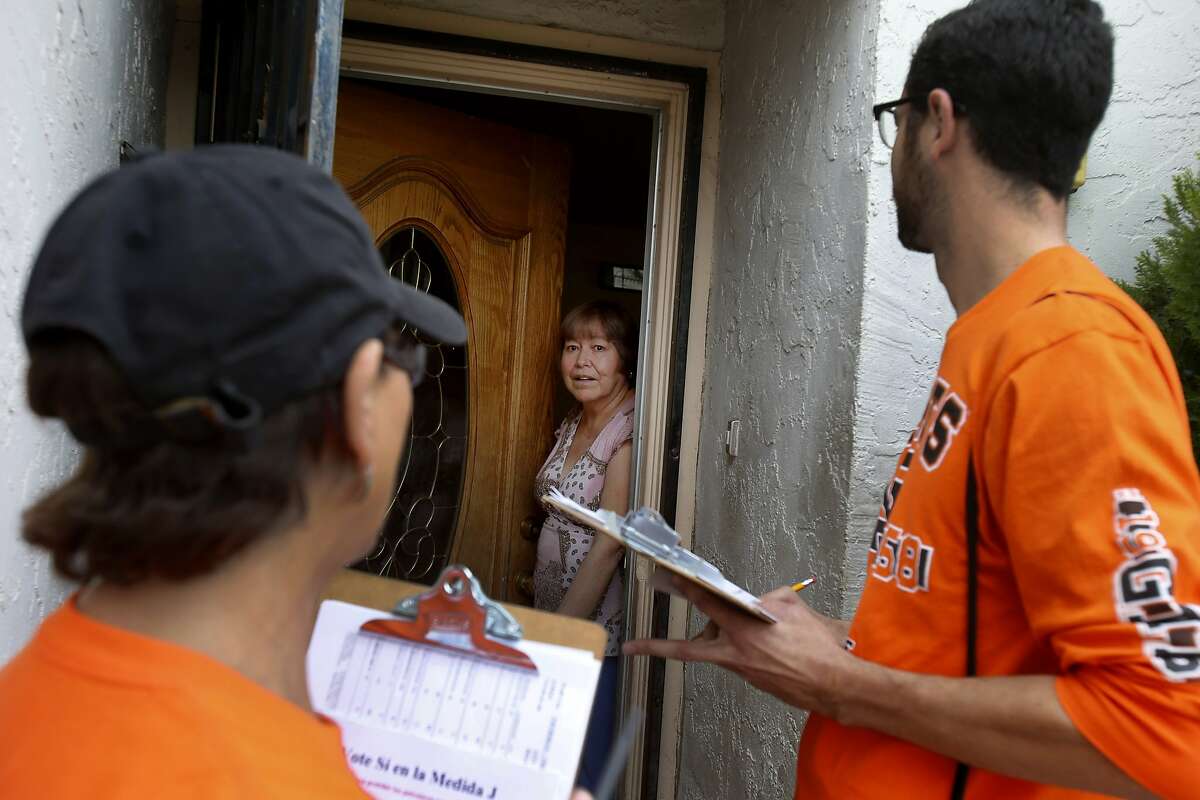 Margaret and Tomas Rebecchi (in Giants orange) talk with a Hollister, Calif. resident about supporting their anti-measure on the ballot Thursday October 30, 2014. In the upcoming election, three California counties will vote on ballot measures to ban fracking (hydraulic fracturing) within their borders. San Benito County's measure would also ban cyclic steam injection and acidization methods.