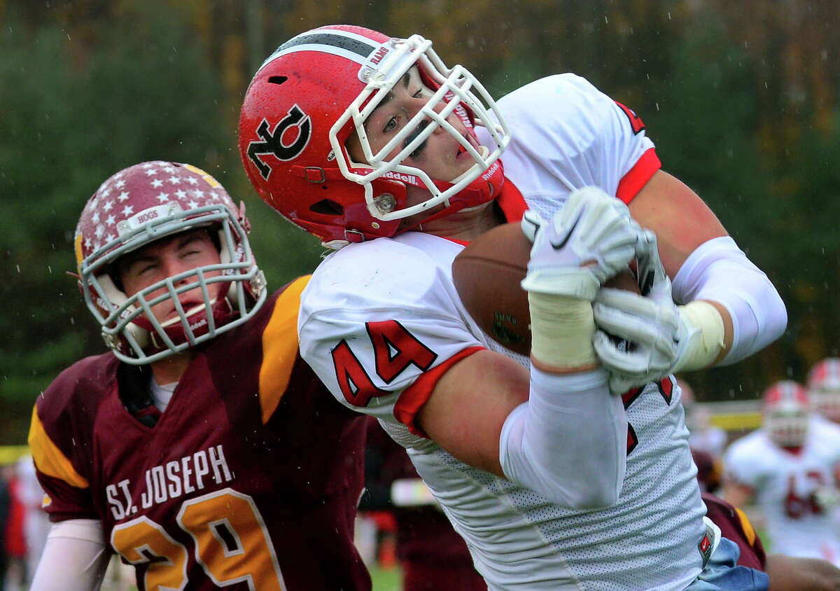 New Canaan's Zachary Allen completes a pass in the endzone for a touchdown, during football action against St. Joseph in Trumbull, Conn. on Saturday, November 1, 2014. At left is St. Joseph's Lars Pedersen.