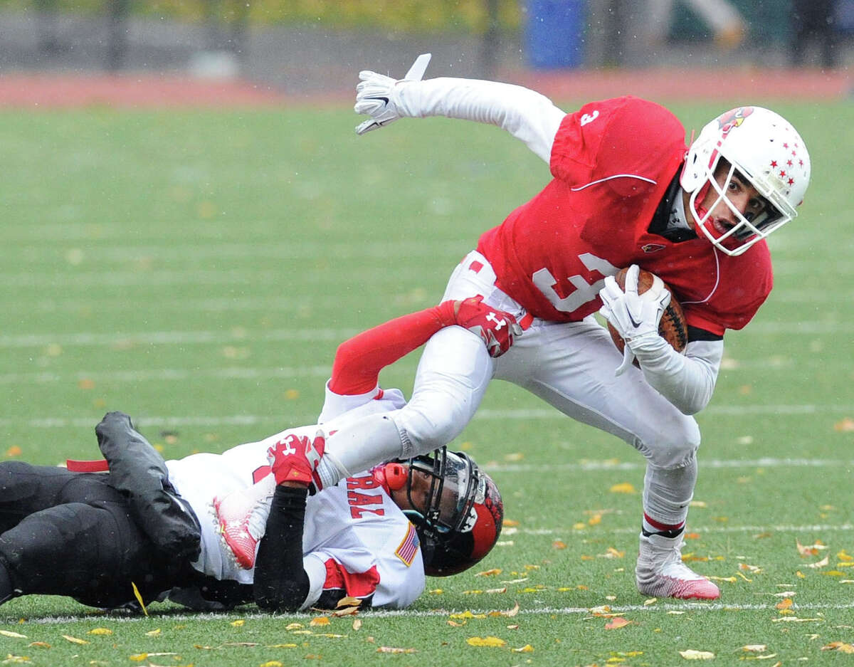 At right, Austin Longi of Greenwich is tackled by Bridgeport Central's Manny Lavant during the high school football game between Greenwich High School and Bridgeport Central High School at Greenwich, Conn., Saturday afternoon, Nov. 1, 2014.