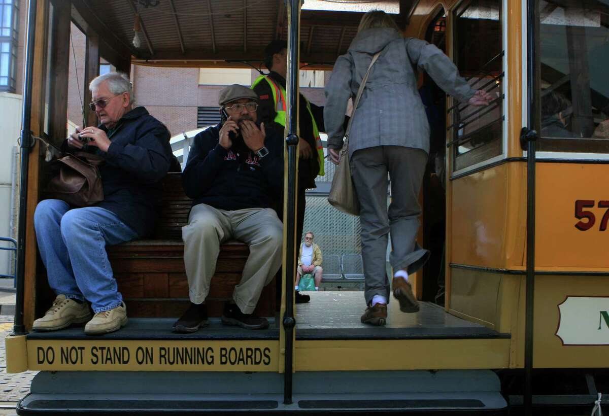 People get on a heritage trolly to take a trip around the city for free at the Muni Heritage Weekend Celebration in front of the Ferry building in San Francisco, Calif., on Saturday November 1, 2014.