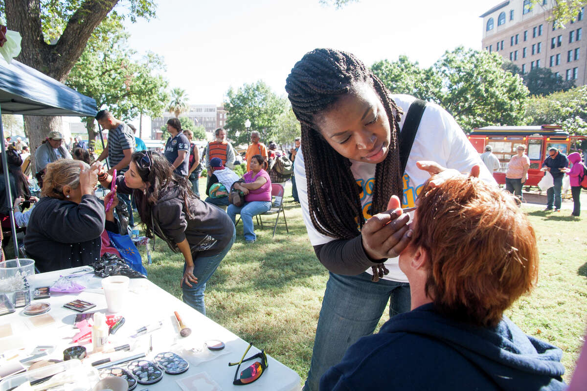 Tanya Workman applies makeup to Tracy May November 1, 2014 during Calvary Chapel of San Antonio 17th annual Joy of Jesus Outreach at Travis Park. The congregation provided more than twenty services for the community including free hair cuts, manicures, and massages.