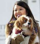 Nina Pham holds up her dog Bentley at Hensley Field in Grand Prairie.  Pham, who recovered from Ebola, and the King Charles Spaniel were reunited privately Saturday in a vacant residence where officers once lived at a former naval air base, where he had been quarantined.
