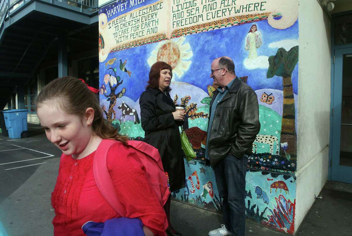 Student Ivy Dubiner (left) is brought to school by mom Carrie Swing (center) and dad David Dubiner in the schoolyard of Harvey Milk Civil Rights Academy in San Francisco on Nov. 3, 2014.