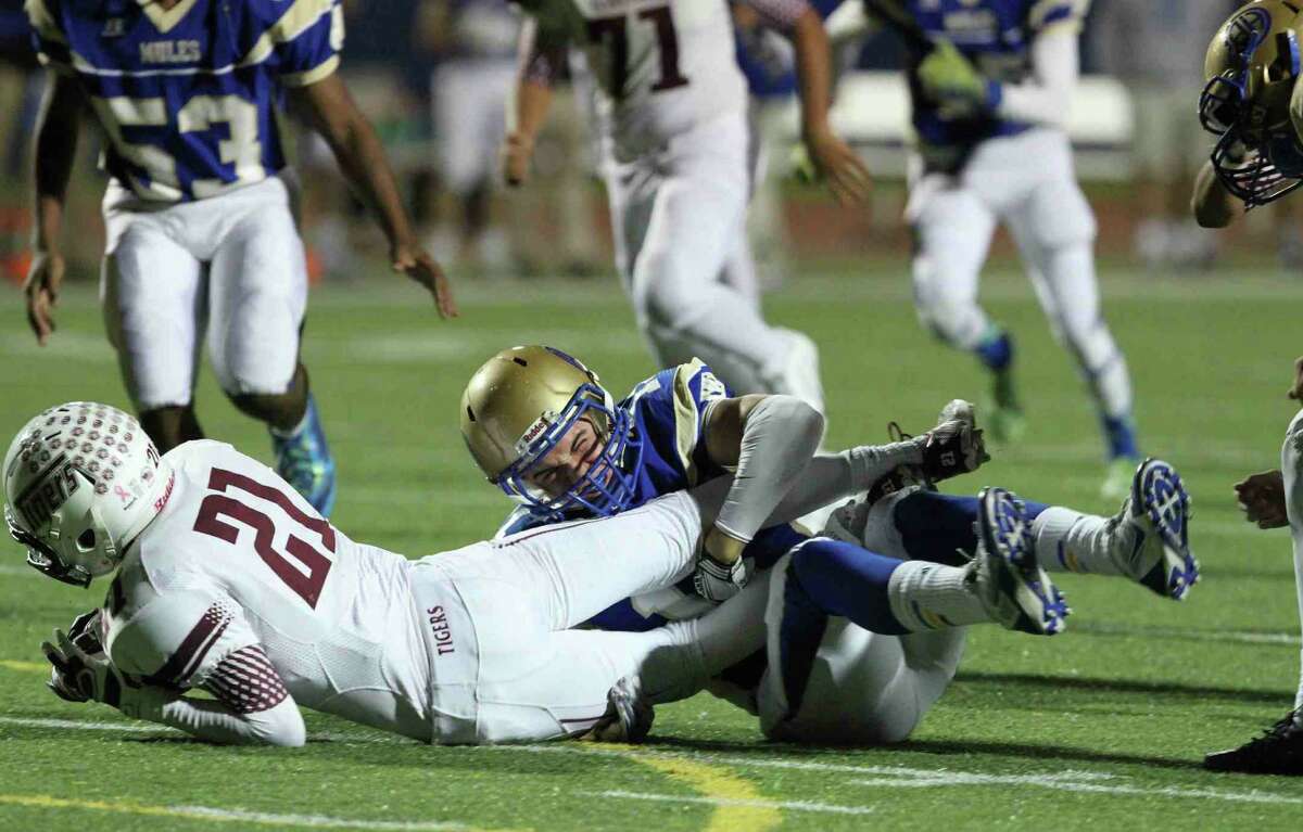 Alamo Heights' Holden Daum tackles Floresville's Dadrian Contreras in the Mules' 47-43 win Oct. 31.