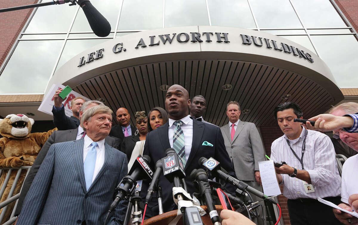 (center) Minnesota Vikings star running back Adrian Peterson speaks with the media before departing from the Montgomery County courthouse in Conroe, TX Tuesday November 4, 2014. Peterson avoided jail time in a plea agreement reached with prosecutors to resolve a child abuse case involving Peterson's 4-year-old son.