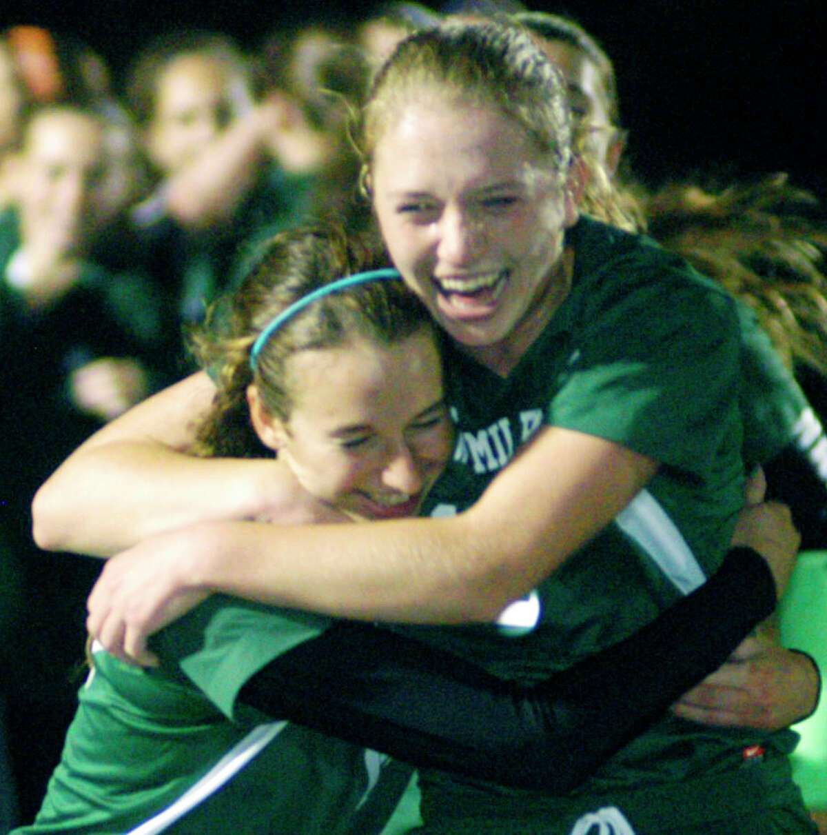 Fellow Green Wave seniors Gigi Fusco and Helen Bayers, right, lead the celebration seconds after the final horn of New Milford High School's 2-1 victory over Masuk in the South-West Conference girls' soccer title match at Newtown High. Oct. 29, 2014