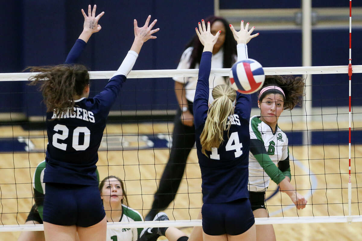Reagan's Elissa Barbosa (from right) watches her shot sail past Smithson Valley's Madeline Ferguson and Kainah Williams during their 6A first-round playoff match at Alamo Convocation Center Nov. 4. Reagan beat the Smithson Valley in three straight sets: 25-17, 25-13, 25-21.