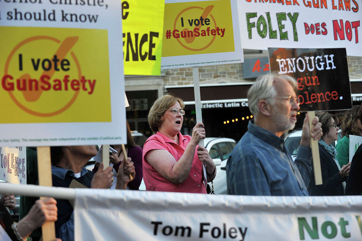 Ellen Letkowski, center, with Newtown Action Alliance, a gun control group, protests New Jersey Gov. Chris Christie's visit to Stamford while he stumps for Connecticut gubernatorial candidate Tom Foley outside Bobby V's Sports Bar in Stamford, Conn., on Tuesday, Sept. 23, 2014.
