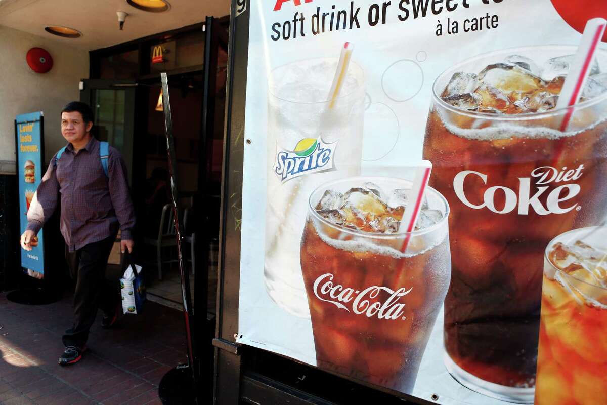 A man walks by a McDonald’s soda poster on Market Street in San Francisco as voters were deciding whether there should be a tax on sugary drinks on Nov. 4, 2014.