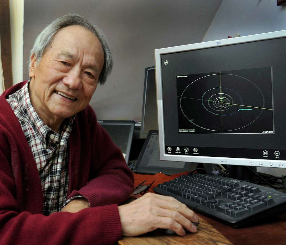 Dr. Phillip Lu, a retired professor of astronomy at Western Connecticut State University, recently had a minor planet named after him - 175450 Phillipklu. Lu is photographed in his Danbury home next to a computer image that shows the planet, Thursday, Nov. 6, 2014.