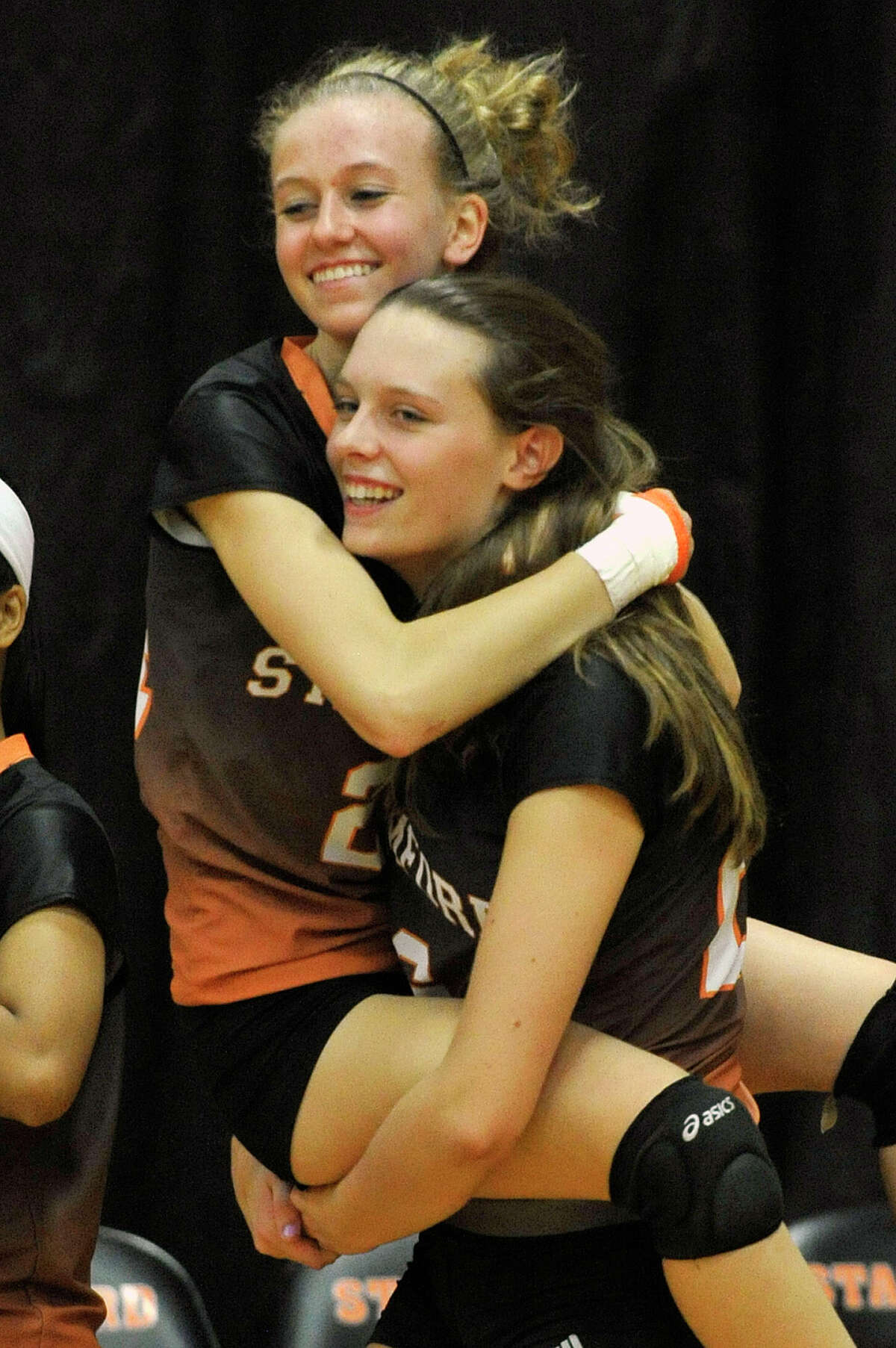 Stamford's Cali Schenkel carries her team mate Liisa Balazs after beating Greenwich, 3-2, in their Class LL second round playoff volleyball match at Stamford High School in Stamford, Conn., on Thursday, Nov. 6, 2014.