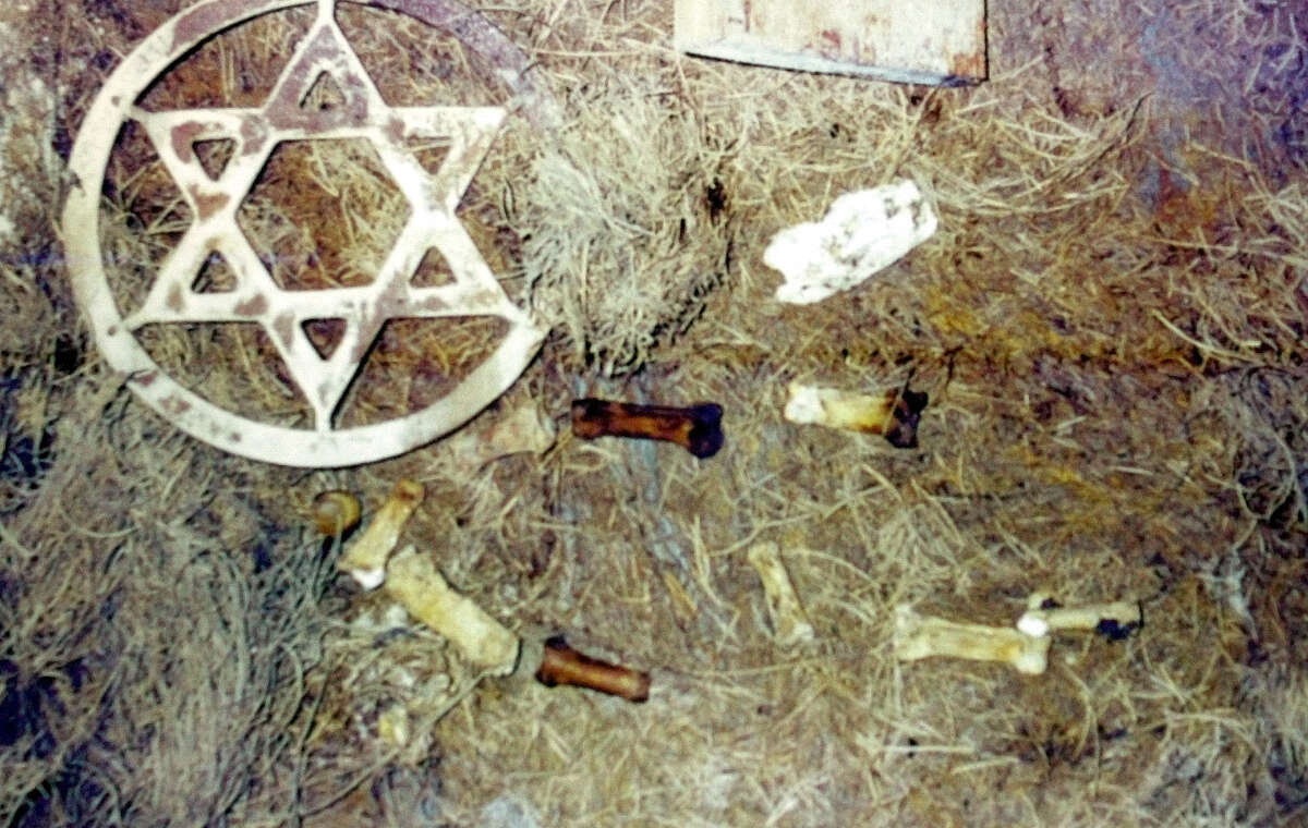 A photograph of a Jewish star along with human bones dumped in a wooded area is seen on display at a news conference announcing a class action lawsuit against Menorah Gardens and Funeral Chapels and its parent corporation, Service Corporation International Thursday, Dec. 20, 2001, in Fort Lauderdale, Fla. Families of the dead are suing Menorah Gardens. They say their loved ones were dug up and dumped in the woods and that vaults were crushed down on top of each other to make room for new sales. (AP Photo/Amy E. Conn)