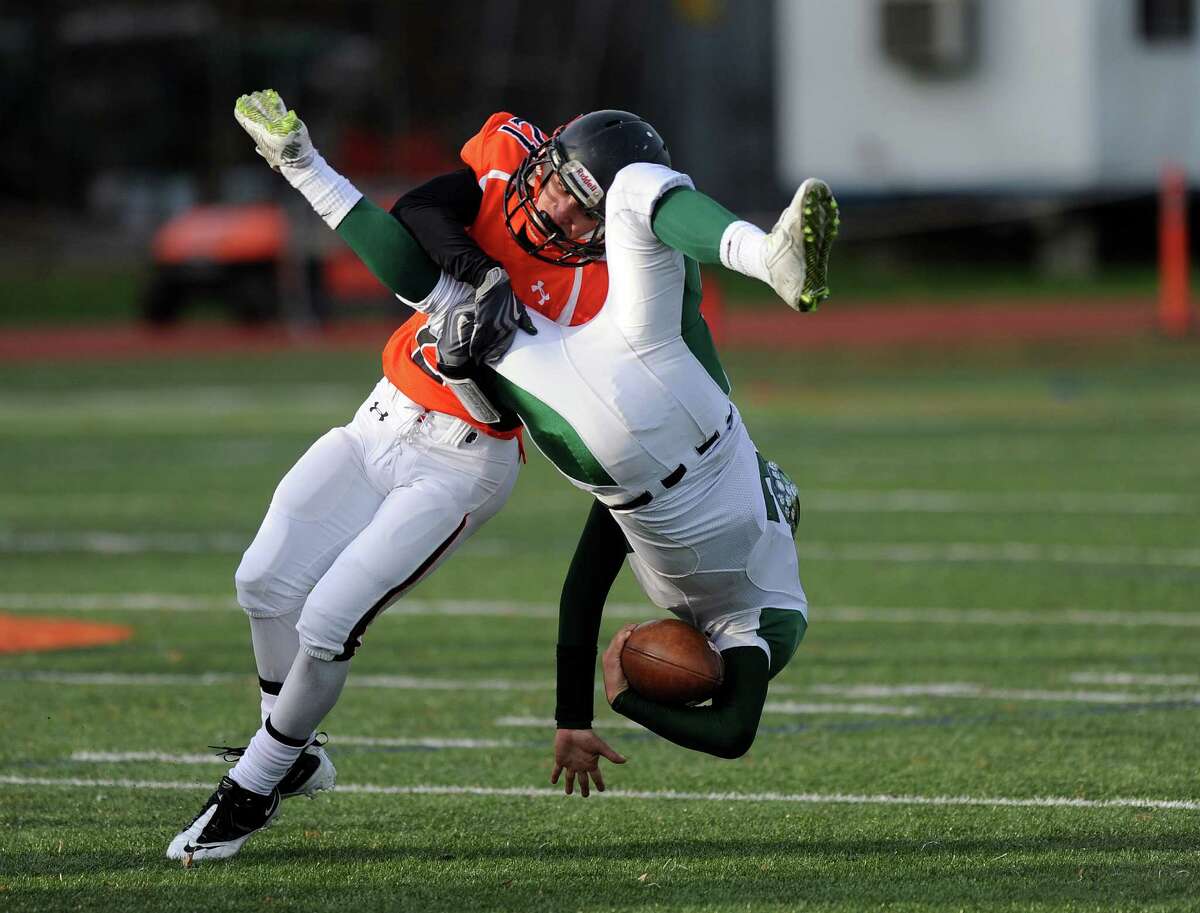 Norwalk's Harrison Hefferan flips as he is tackled by Stamford's Mark Serricchio during Saturday's football game on November 8, 2014, at Stamford High School.