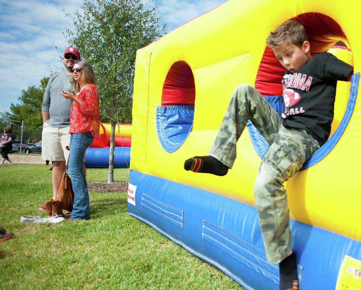 Everett Morrison, 7, plays in an inflatable obstacle course while his parents Brian and Leslie Morrison watch other children with Texas Child Protective Services at an adoption festival sponsored by the Pearland Rotary on Saturday, Nov. 8, 2014 at the Silverlake Clubhouse in Pearland, Texas. The Morrisons said they always wanted to adopt a child and are looking to find one or two siblings to raise with their two biological children.