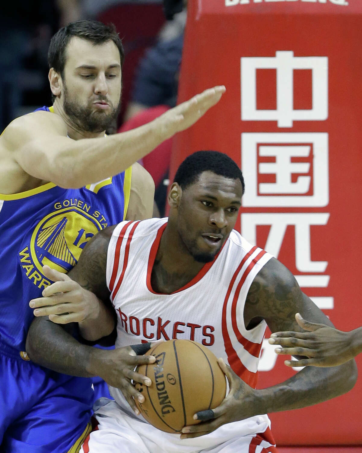 Andrew Bogut, who had eight points and 18 rebounds, defends against the Rockets’ Tarik Black in the first half.