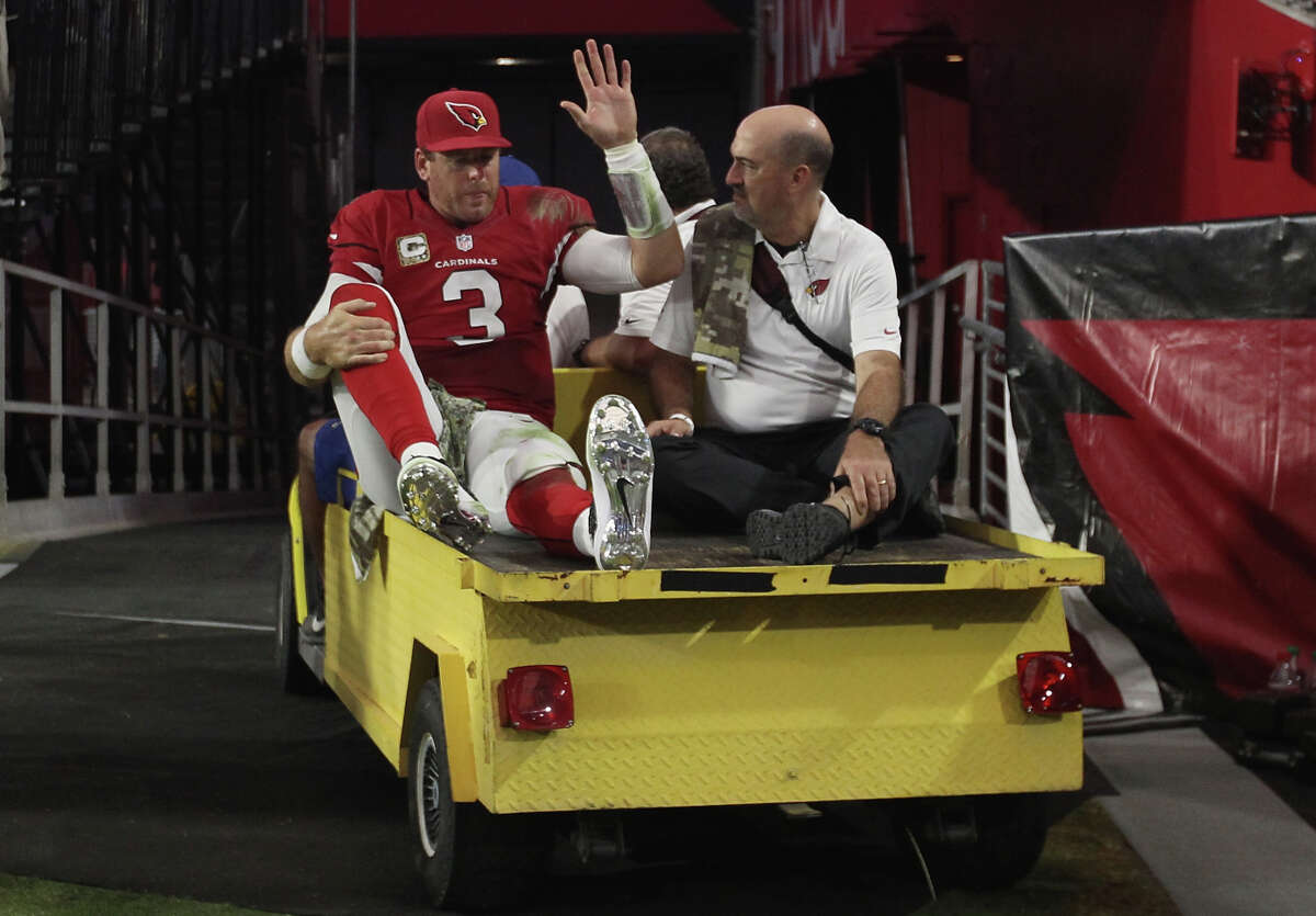 Cardinals quarterback Carson Palmer, who on Friday signed a three-year contract extension worth a reported $50 million, is taken to the locker room after hurting his knee Sunday.