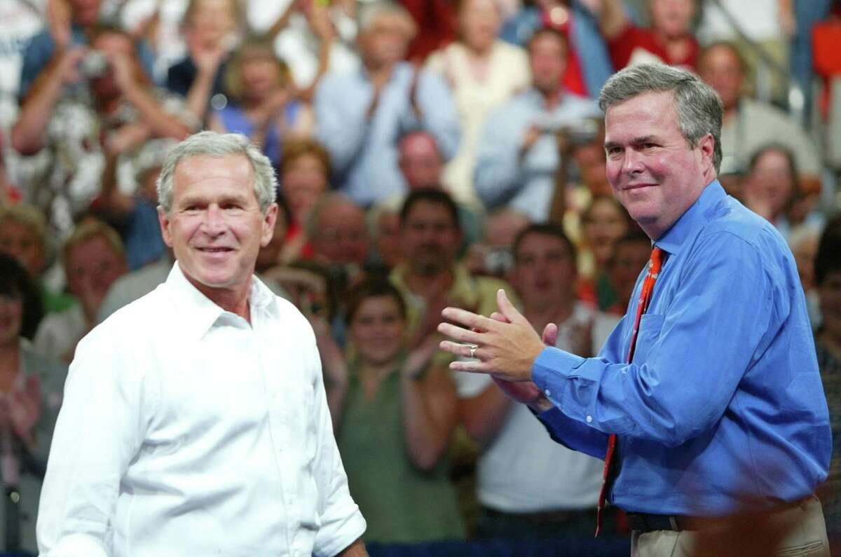 FILE - In this Aug. 10, 2004 file photo, President George W. Bush, left, is introduced by his brother Florida Gov. Jeb Bush, right, at 'Ask President Bush' campaign rally, at Okaloosa-Walton Community College Gymnasium in Niceville, Fla. President George W. Bush is giving even odds to an attempt at a family legacy as part of the 2016 White House campaign, saying Sunday Nov. 9, 2014 on âFace the Nationâ on CBS his brother Jeb Bush is âwrestling with the decision.â (AP Photo/Pablo Martinez Monsivais, File)
