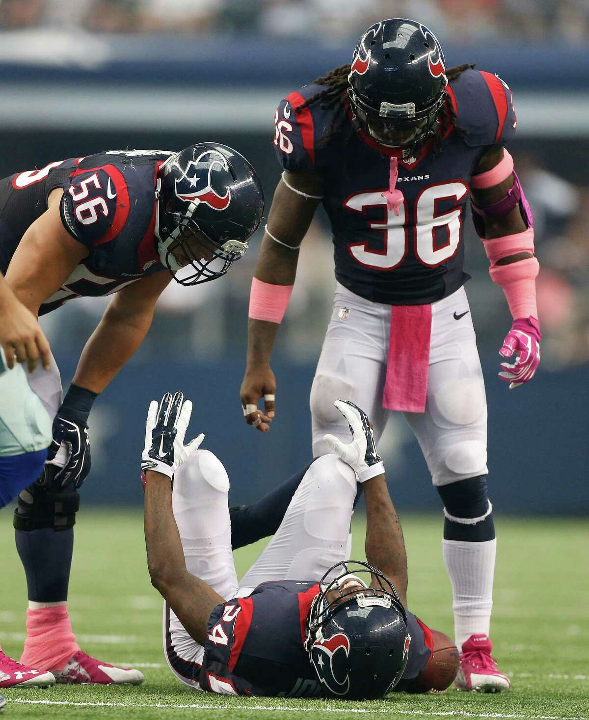 Houston Texans cornerback Johnathan Joseph (24) lies on the ground injured as Brian Cushing (56) and D.J. Swearinger (36) check on him during the third quarter of an NFL football game at AT&T Stadium, Sunday, Oct. 5, 2014, in Arlington. ( Karen Warren / Houston Chronicle )