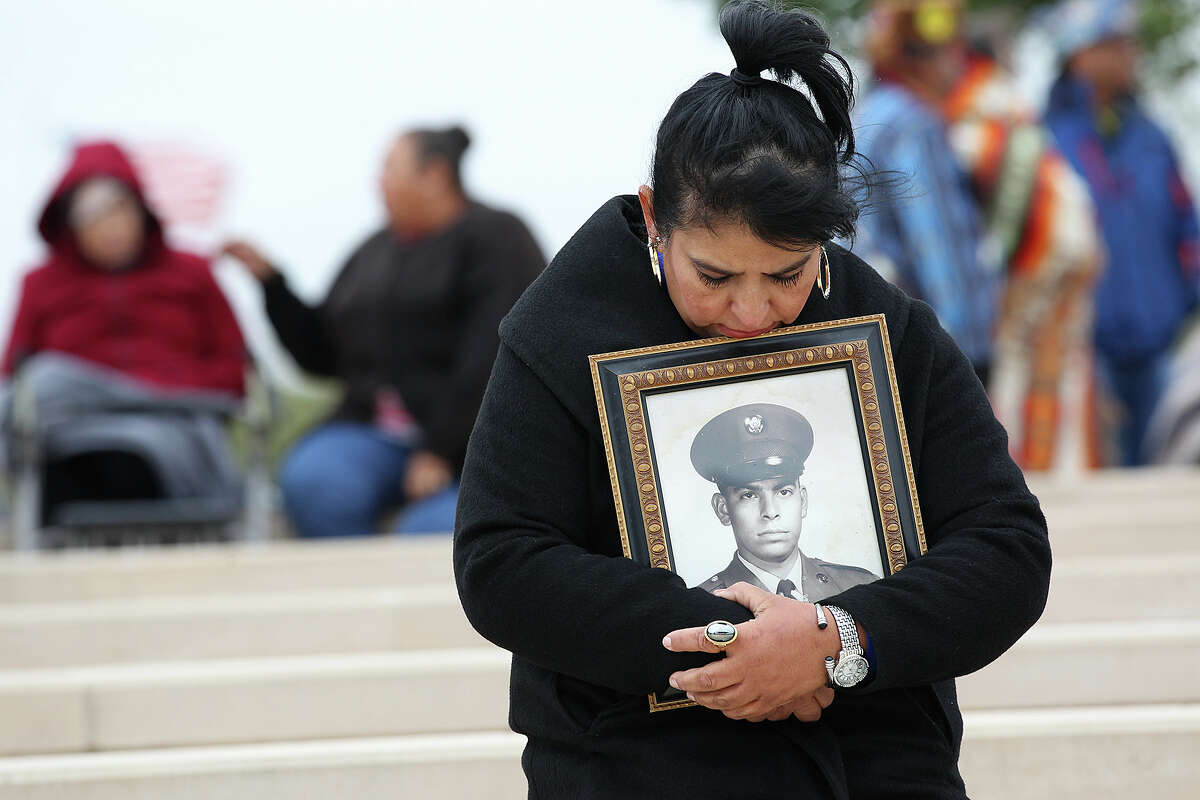 Maria Becerra, 53, holds a portrait of her father, U.S. Army veteran Cesario Becerra, before as people gather to honor soldiers and veterans during a Veteran's Day tribute at Fort Sam Houston National Cemetery, Tuesday, Nov. 11, 2014. Becerraâ€™s father died five year ago and served two tour during the Vietnam War.