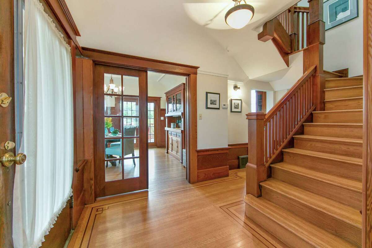 The foyer showcases inlaid hardwood floors and connects to the staircase, dining room and living room. 