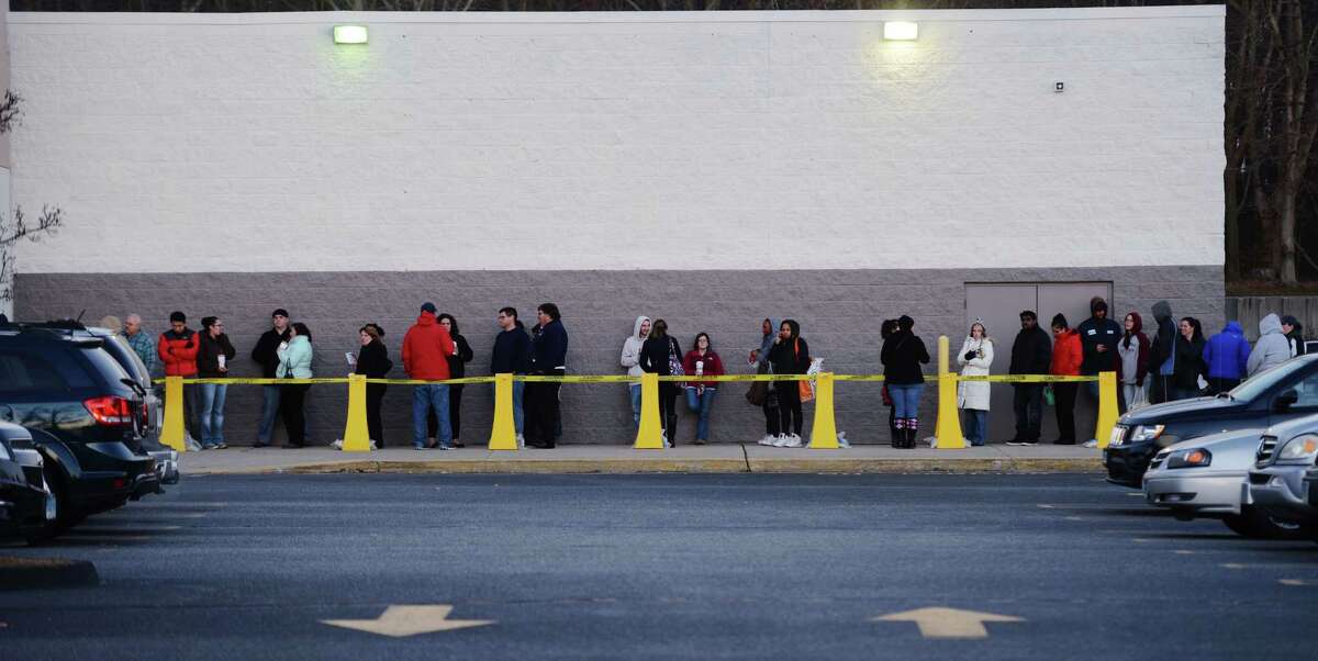 Consumers wait to shop in Waterford, Conn., on Thanksgiving Day last year.