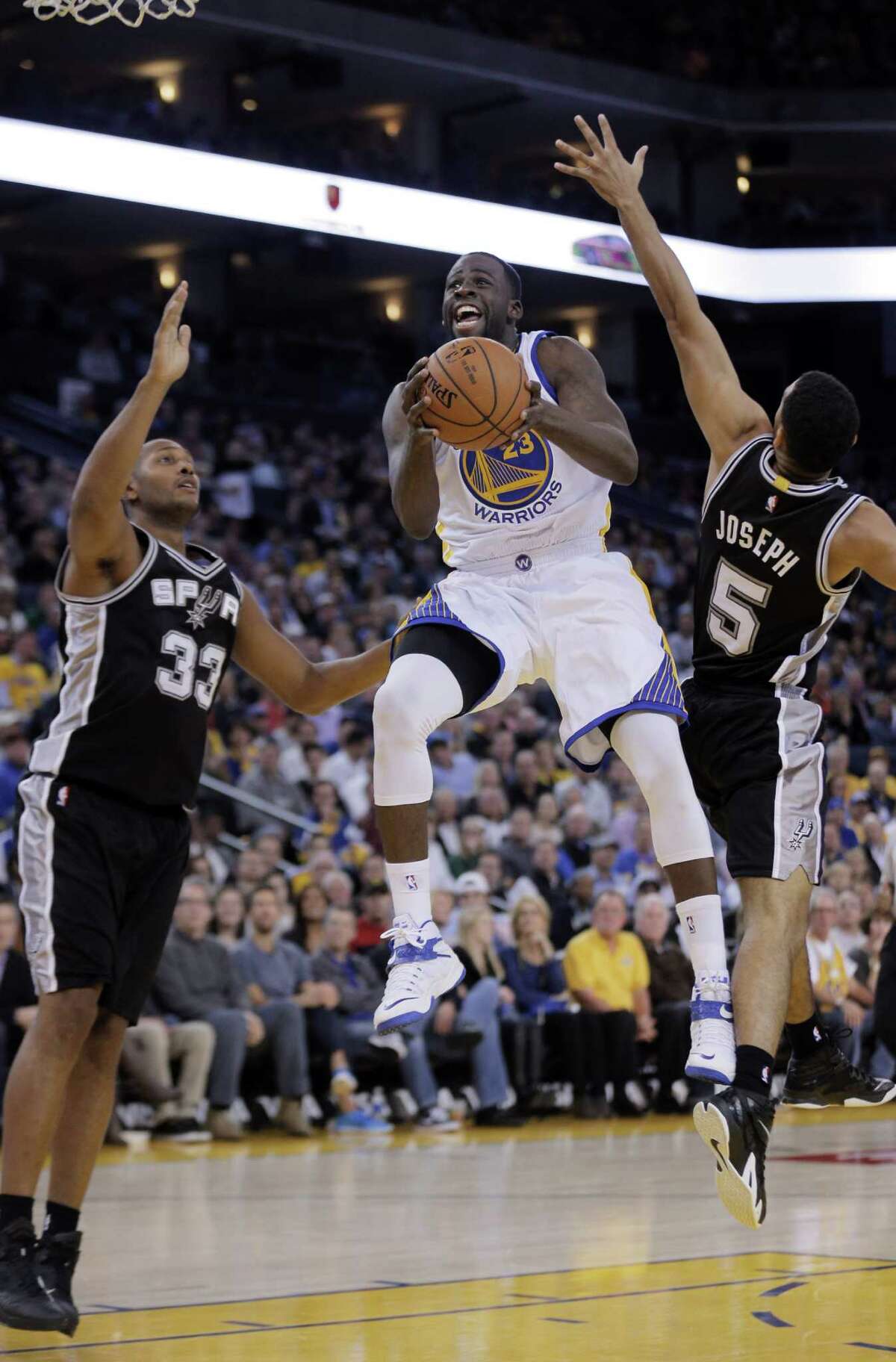 Draymond Green (23) drives to the basket in the first half. The Golden State Warriors played the San Antonio Spurs at Oracle Arena in Oakland, Calif., on Tuesday, November 11, 2014.