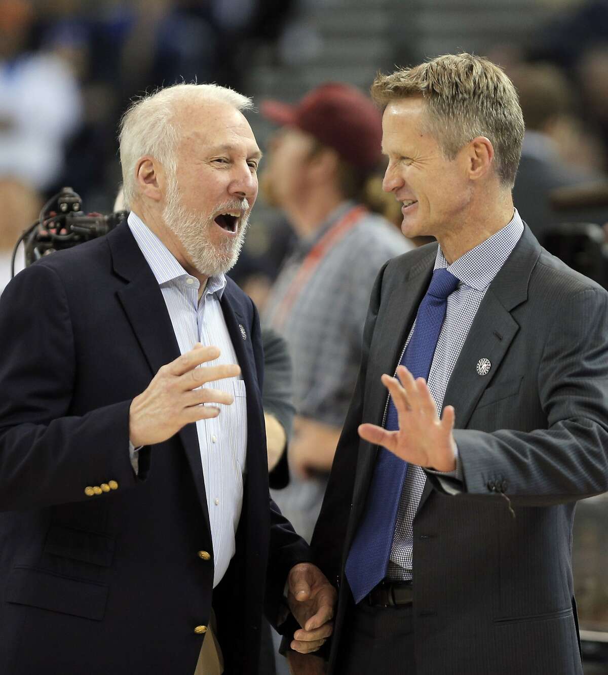 Spurs head coach Gregg Popovich, left, and Warriors head coach Steve Kerr, right, share a few words before the beginning of the teams' game on Nov. 11, 2014.