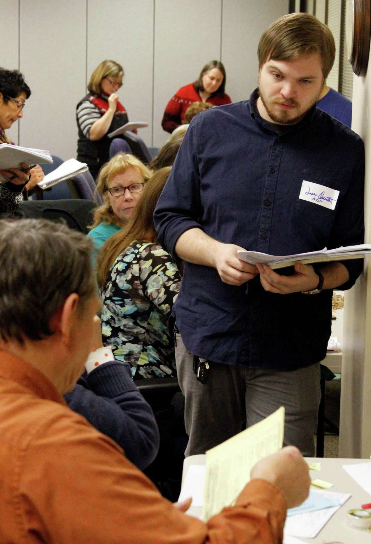 Jesse Overton, an observer for the Alaska Democratic Party, watches workers examine a ballot Tuesday at the Division of Elections office in Anchorage. Workers in Anchorage and other regional centers began counting thousands of absentee and questioned ballots on Tuesday.