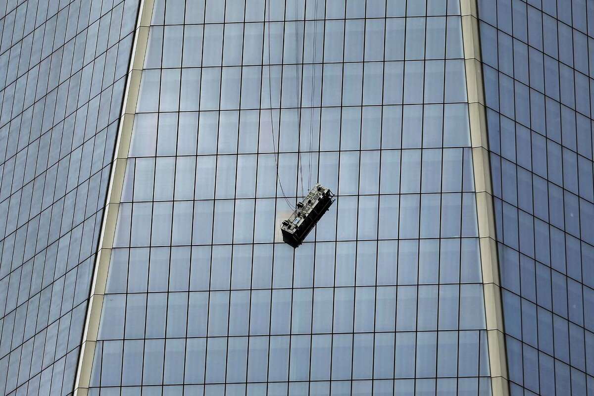 NEW YORK, NY - NOVEMBER 12: A scaffold carrying two workers hangs 69 floors up at One World Trade Center on November 12, 2014 in New York City. The workers were washing windows 69 floors up soon after 1 World Trade Center, the tallest building in the Western Hemisphere, opened. (Photo by Spencer Platt/Getty Images)