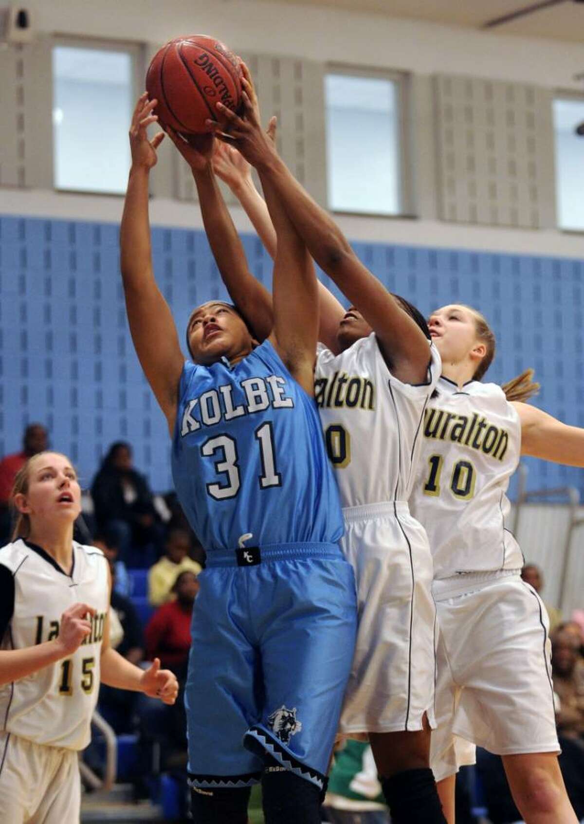 Kolbe Cathedral's Cherelle Moore and Lauralton Hall's Keylantra Langley and Kristina McCathy battle for the rebound during the South-West Conference semi-final game Wednesday Feb. 24, 2010 at Oxford High School.