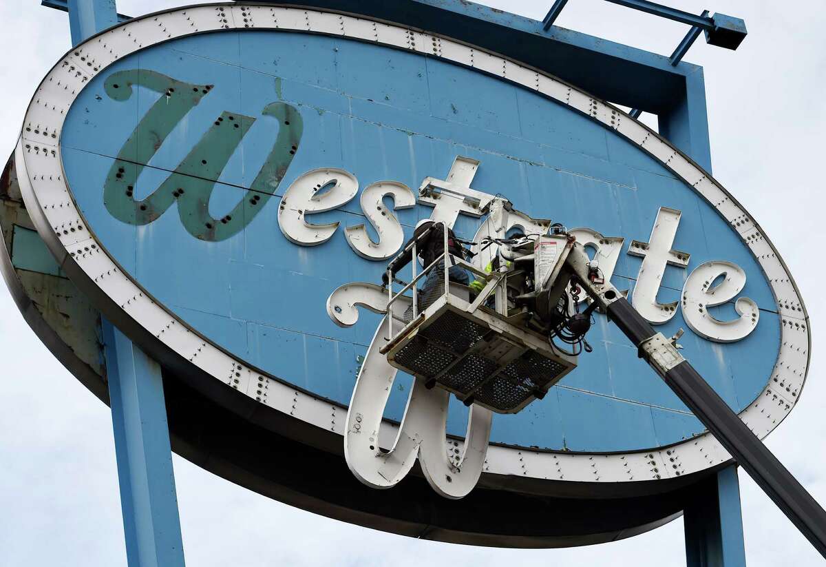 Antonio Flores, left, and David Delano of Saxton Sign Company lower the W from the sign in front of the Westgate Shopping Center Thursday afternoon Nov. 13, 2014 in Albany, N.Y. The landmark sign is being dismantled for renovation. (Skip Dickstein/Times Union)