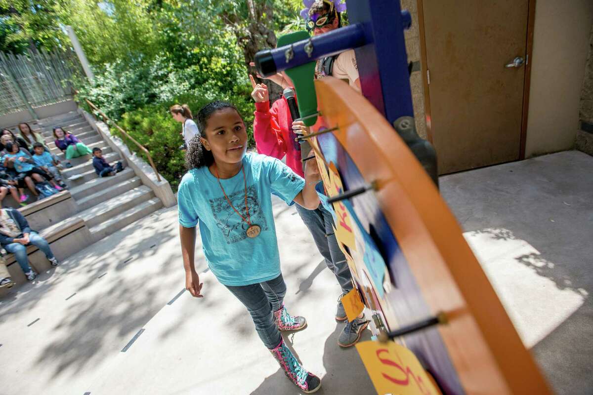 Tati Williams, 9, spins the wheel while playing the eco exploration trivia game during the Oakland ZooCamp summer camp.