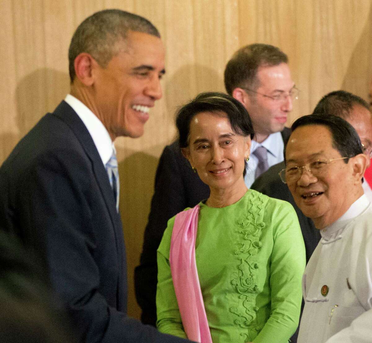 Myanmar's opposition leader Aung San Suu Kyi, center, and President Barack Obama greet participants following a meeting at Parliamentary Resource Center in Naypyitaw, Myanmar. At right is Hla Myint Oo, a member of parliament.
