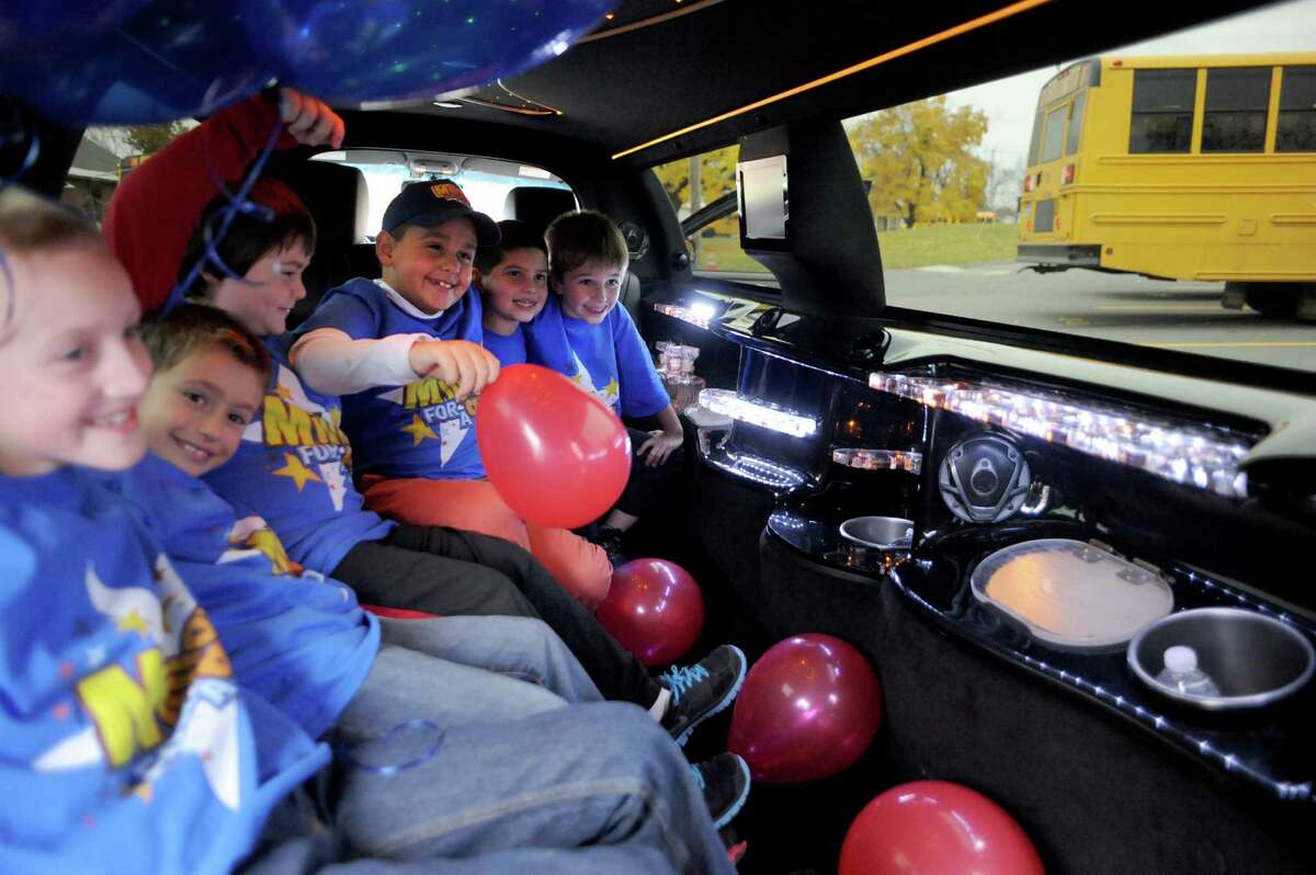 Nikos Johnson, center with balloon, a third grade student at Jefferson Elementary School gets picked up from school by limo with five of his friends after winning the First New York Federal Credit Union's Millionaire for the Day on Thursday Nov. 13, 2014 in Rotterdam, N.Y. First New York Federal Credit Union has been teaching thousands of area students for years to save their money through its KID$ (Keep Investing Dollars Savings) Program. To celebrate the studentsa success, the credit union randomly selected a school banker to be treated like a Millionaire. As the Millionaire for the Day, Nikos Johnson and his classmates will be treated to a waiter-served lunch. In addition, Nikos and five of his friends will be picked up from Jefferson Elementary School at dismissal time and the red carpet will be rolled out treating them to a limousine ride to First New York Federal Credit Unionas headquarters at 2 Wall Street, Albany where they will meet the President/CEO, Lucy Halstead and members of the Board of Directors, receive a personal tour of the credit union and return home via limousine at the end of the day. Mr. Joby Gifford, Principal at Jefferson Elementary School. Nikos, like many other students at Jefferson Elementary School make deposits each week from money they have earned by doing chores, receiving allowance and birthday money. Some students deposit money into their savings account from the soda bottles they help return, while others often find money on the ground. (Michael P. Farrell/Times Union)