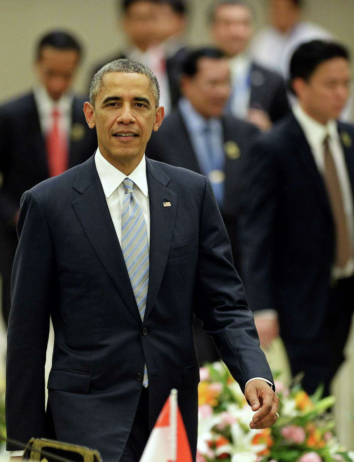 US President Barack Obama walks back to his seat after posing for a "family picture" during the 2nd ASEAN-US Summit at the Myanmar International Convention Center in Myanmar's capital Naypyidaw on November 13, 2014. The Association of Southeast Asian Nations (ASEAN) and East Asia summits, held in the purpose-built capital of Naypyidaw this week, are the culmination of a year of diplomatic limelight for Myanmar after long decades shunted to the sidelines under its former military rulers. AFP PHOTO / Christophe ARCHAMBAULTCHRISTOPHE ARCHAMBAULT/AFP/Getty Images