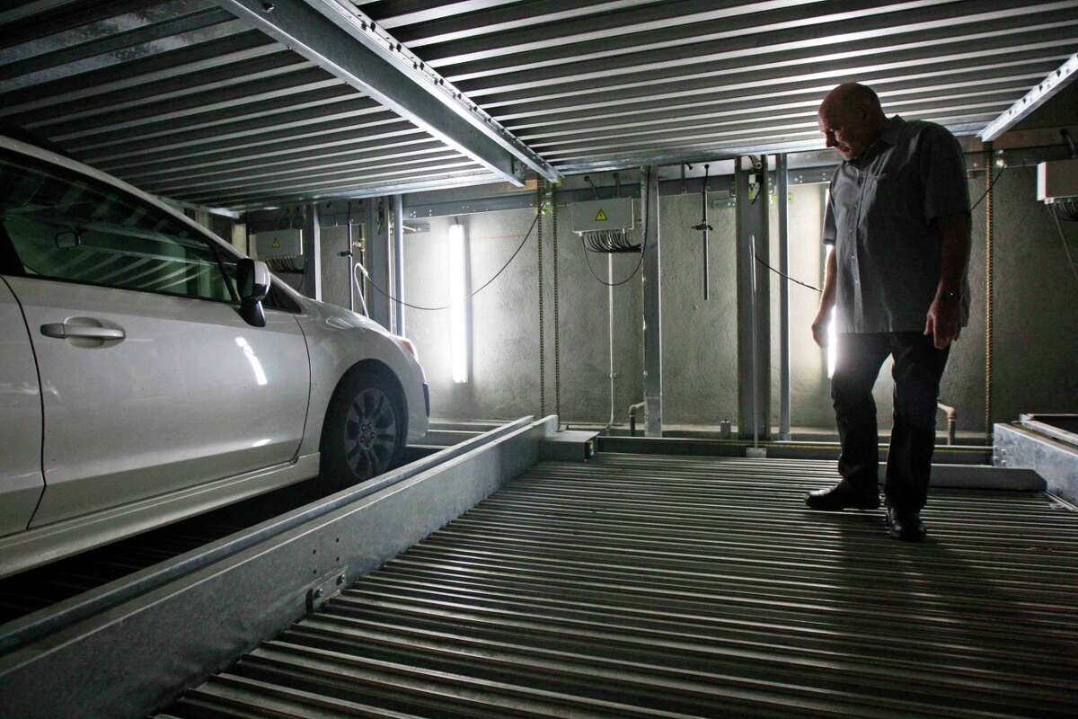 Richard La Rose, an English teacher at Academy of Art University, walks through his designated parking spot inside his apartment building in San Francisco on Nov. 14, 2014. La Rose pays a $295 school district support tax twice on both his condo and his parking space, which the city recognizes as a second residence.