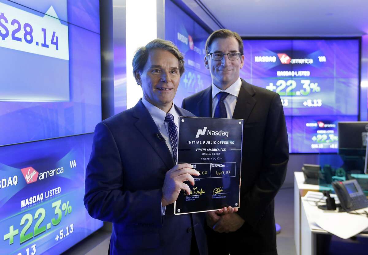 David Cush, left, President & CEO of Virgin America, poses for photos with Nasdaq CEO Robert Greifeld and his IPO certificate after Virgin America began trading at the Nasdaq MarketSite, in New York, Friday, Nov. 14, 2014. The shares opened at $27 — $4 higher than the price that the airline set — and then jumped as high as $29.74 within about an hour of the opening bell. (AP Photo/Richard Drew)
