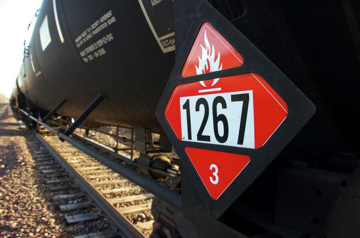FILE - This Nov. 6, 2013 file photo shows a warning placard on a tank car carrying crude oil near a loading terminal in Trenton, N.D. Thousands of older rail tank cars that carry crude oil would be phased out within two years under regulations proposed in response to a series of fiery train crashes over the past year. The oil industry's lead trade group released new standards on Thursday, Sept. 25, 2014, for testing and classifying crude shipped by rail after prior shipments were misclassified, including a train that derailed in Canada and killed 47 people. (AP Photo/Matthew Brown, File)
